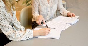 Women signing documents